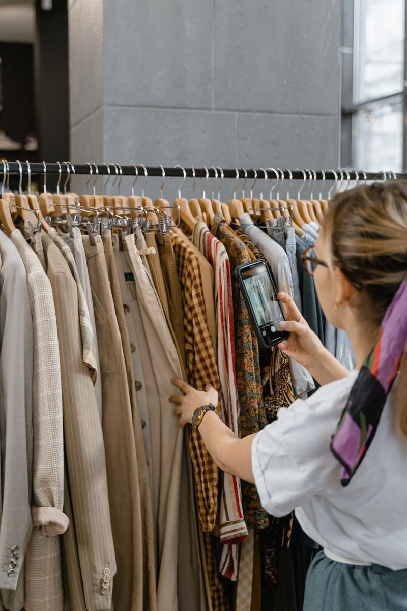 Profissional usando o celular dentro de uma loja de roupas